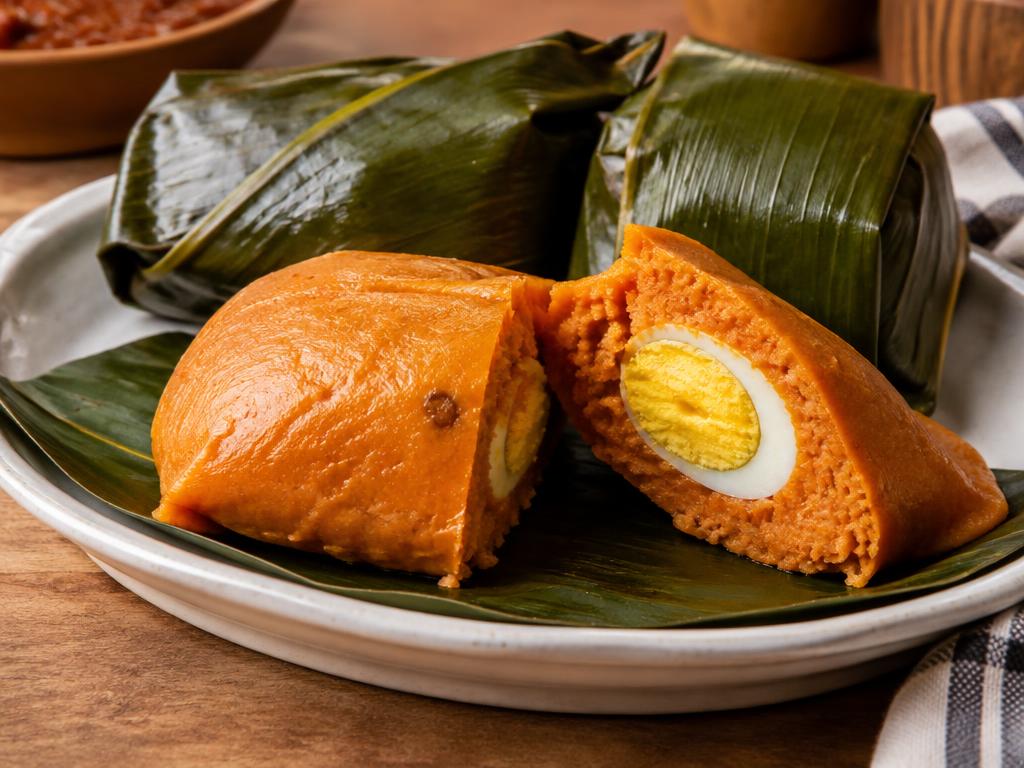 Nigerian moi moi steamed bean pudding with boiled egg, wrapped in leaves