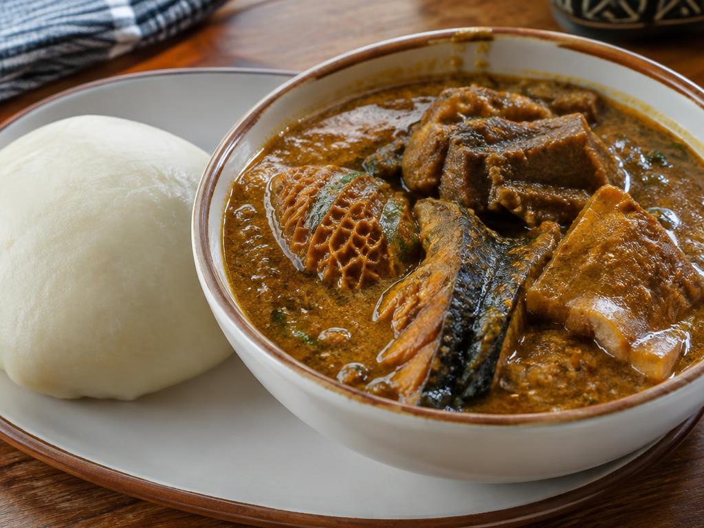 Nigerian ogbono soup with assorted meat and smoked fish, served with fufu