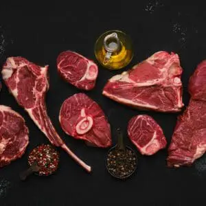 Variety of raw meats with seasoning.