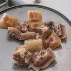 Chopped meat pieces on a metal plate.
